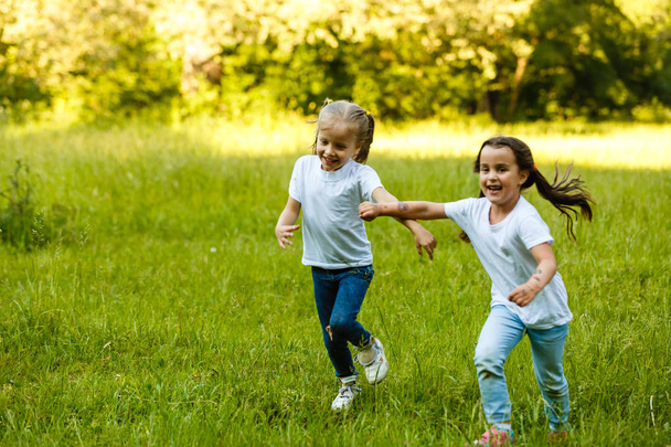 Happy children running in green summer park - Photo, Image