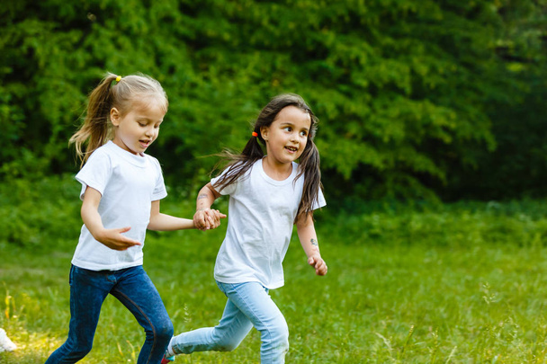 緑の夏の公園で走っている幸せな子供たち - 写真・画像