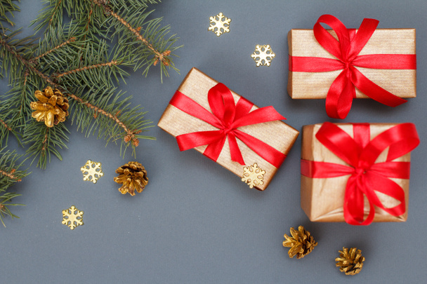 クリスマス装飾。ギフト用の箱、灰色の背景にコーンと天然のモミの木の枝します。平面図です。クリスマスのグリーティング カードの概念. - 写真・画像