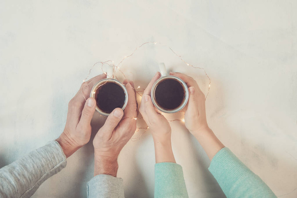 Couple in love holding hands with coffee on white marble table. Photograph taken from above, top view with copy space - Fotografie, Obrázek