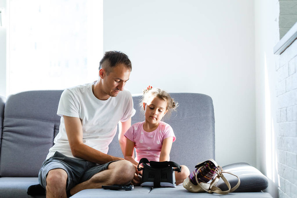 Father and daughter playing with virtual reality at home - Fotografie, Obrázek