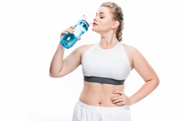 young overweight woman in sportswear drinking water isolated on white - Valokuva, kuva