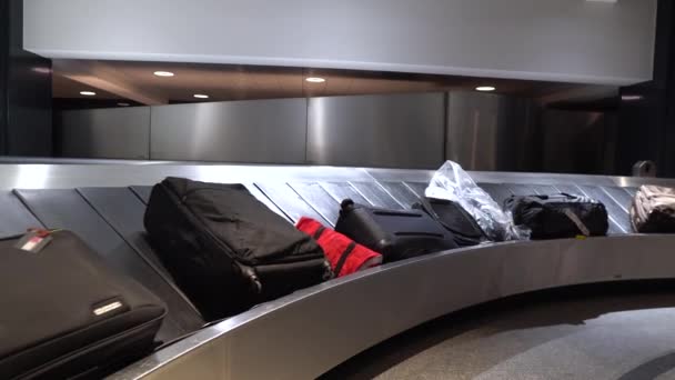 Koffer of bagage op bagage circulerende transportband in de bagageband in de aankomst internationale luchthaven terminal. Reizen-vakantie en vervoer-concept. - Video