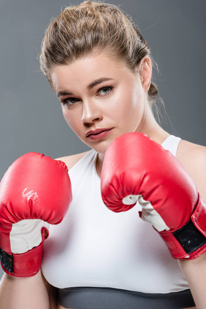 beautiful  young woman in boxing gloves looking at camera isolated on grey - Φωτογραφία, εικόνα