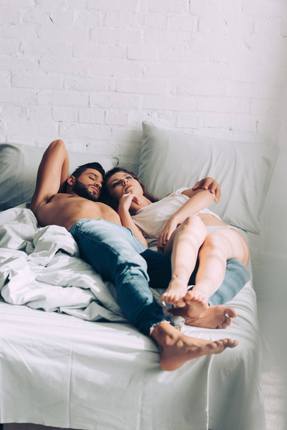 selective focus couple embracing and laying on bed in morning at home - Foto, Imagen