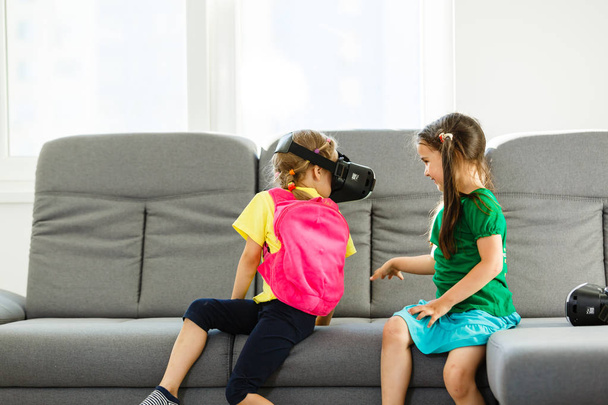 two little girls using virtual reality goggles in living room at home - Photo, Image