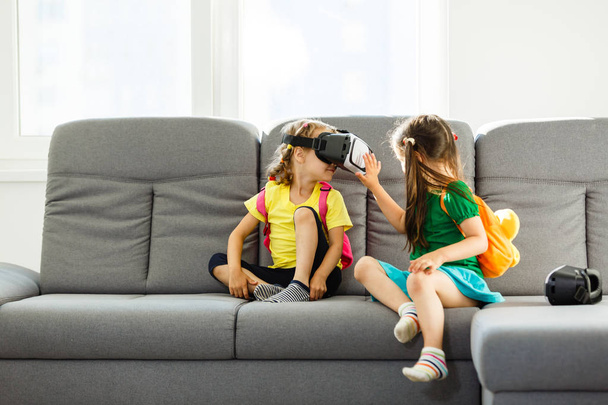 自宅のリビング ルームで二人の少女を用いた仮想現実ゴーグルします。 - 写真・画像