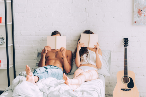 высокий угол зрения купе чтение и покрытие лиц книгами в спальне на дому
 - Фото, изображение