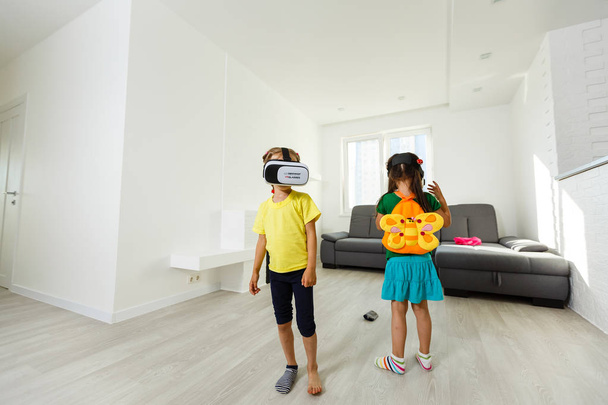 deux petites filles utilisant des lunettes de réalité virtuelle dans le salon à la maison
 - Photo, image