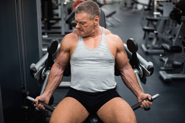 Grand homme athlétique s'entraîne dans la salle de gym. Formation des biceps
 - Photo, image