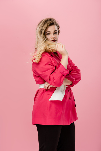 beautiful young plus size woman in pink jacket looking at camera isolated on pink - Zdjęcie, obraz