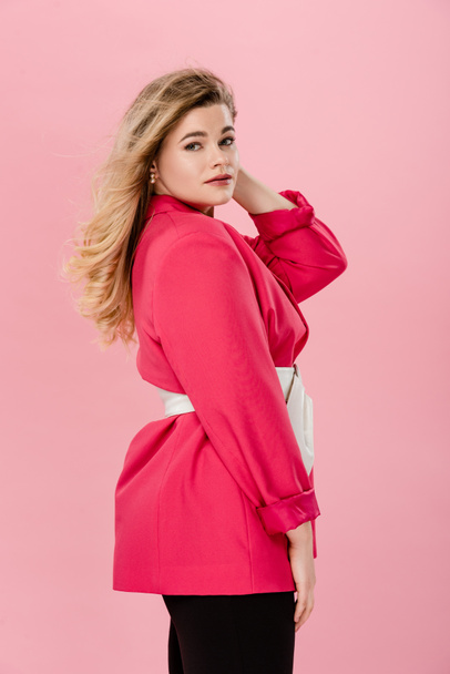 side view of beautiful stylish oversize woman looking at camera isolated on pink  - Foto, Imagem