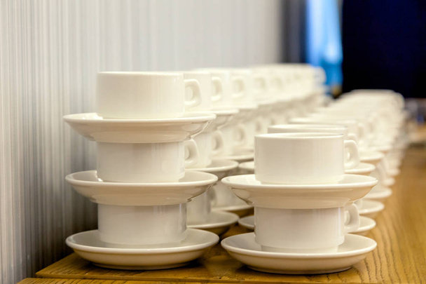 A sok fehér porcelán tea pár cölöpök egy egyenes vonal. Koncepció konferencia a hotelben, szünet, vendéglátás, reggeli - Fotó, kép