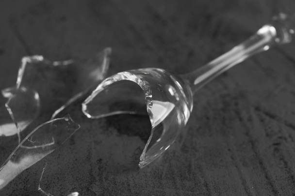 Gebroken wijnglas op een concrete achtergrond - Foto, afbeelding