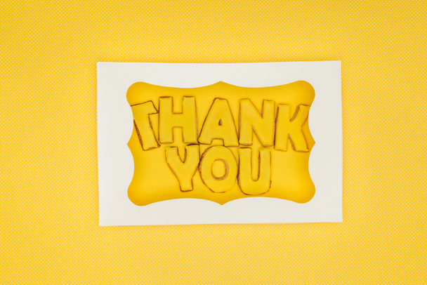 square-shaped cake in box with thank you lettering isolated on yellow background - Valokuva, kuva