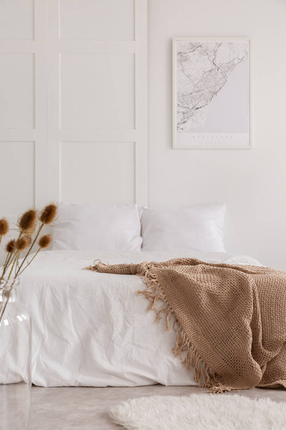 Vertical view of white bedroom interior with natural materials and map on the wall, real photo - Foto, Imagen