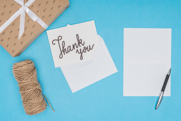 white postcard with thank you lettering and blank sheet isolated on blue background - Photo, Image
