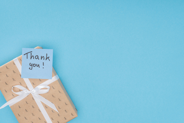  sticky note with thank you lettering on gift box isolated on blue background  - Zdjęcie, obraz