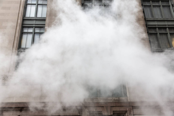 NEW YORK, USA - May 03, 2016: Manhattan street scene. Cloud of vapor from the subway on the streets of Manhattan in NYC. Typical view of Manhattan - Фото, зображення