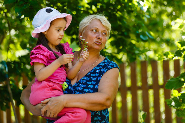 Feliz avó posando com a menina no jardim
  - Foto, Imagem