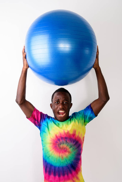 Estudio de tiro de joven negro africano hombre sosteniendo gran bola de ejercicio
 - Foto, imagen