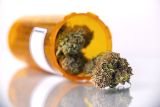 medizinisches Marihuana-Konzept mit trockenen Cannabis-Knospen isoliert auf weißer reflektierender Oberfläche - Foto, Bild