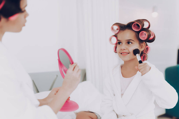 Mother and Girl Adorable Care for Face. Mother and Daughter in Bathrobe. Beauty Saloon at Home. Coloration Face. Cosmetic for Young Girl and Young Mother. Glamour Young Girl and Glamour Cute Mother. - Photo, image