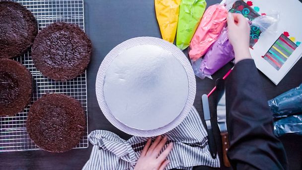 Stap voor stap. Flat lag. Monteren van een chocoladecake met heldere kleurrijke botterroom berijpen voor Dia de los Muertos vakantie Baker. - Foto, afbeelding