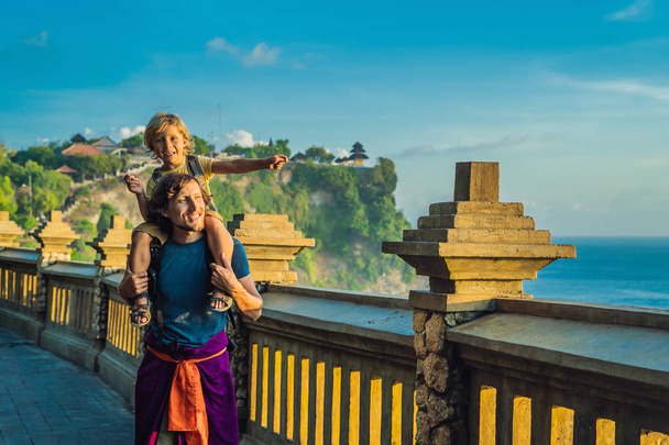 Father carrying on shoulders little son while trip in Pura Luhur Uluwatu temple, Bali, Indonesia. - Photo, image