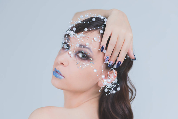 Зимняя красавица. Модная девушка-модель в стиле снежинки и макияжа. Макияж и маникюр. Зимняя королева со снегом и ледяной прической - Фото, изображение