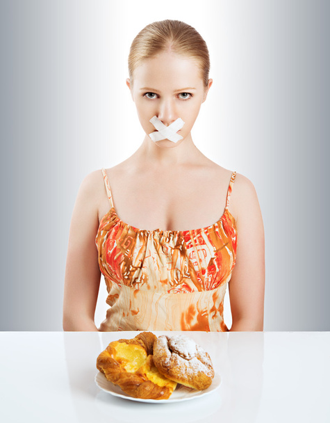 Ernährungskonzept. Frauenmund mit Klebeband mit Brötchen verschlossen - Foto, Bild