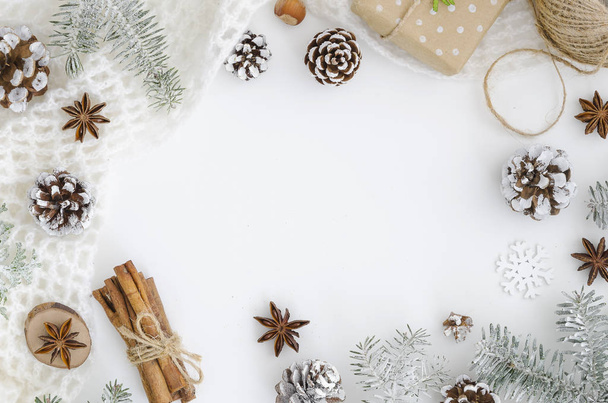 Κάσια Χριστούγεννα από χέρι διακόσμηση Χριστουγέννων, κώνους, ξυλάκια κανέλας, γλυκάνισο αστέρια σχοινί. συσκευασία δώρου. Μοντέρνα mockup με αντίγραφο χώρο. Λευκό ελάχιστη καλυμμένα με χιόνι - Φωτογραφία, εικόνα