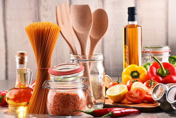 Composición con diversos productos alimenticios y utensilios de cocina sobre la mesa
 - Foto, Imagen