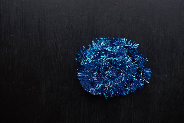 blue tinsel on dark background - Фото, зображення