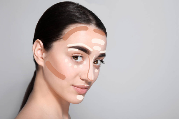 Beautiful young woman with different color foundations on face against grey background, space for text. Makeup contouring - Φωτογραφία, εικόνα