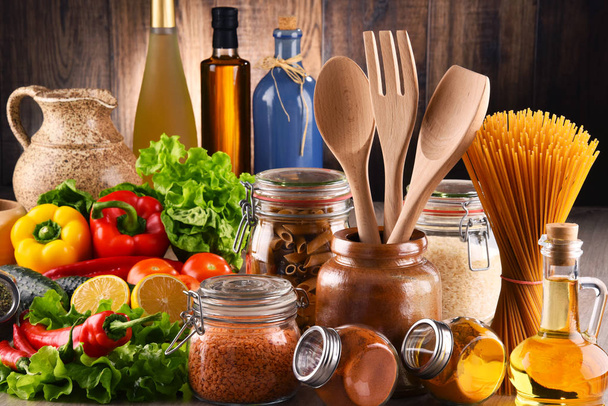 Composición con diversos productos alimenticios y utensilios de cocina sobre la mesa
 - Foto, Imagen