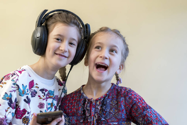 Duas meninas felizes juntas ouvindo música
 - Foto, Imagem