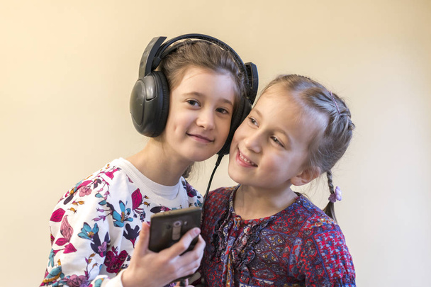 Deux petites filles ensemble écoutent de la musique
 - Photo, image