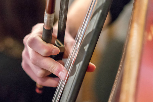 Hand eines Cello spielenden Mädchens in Großaufnahme. Kontrabass. - Foto, Bild