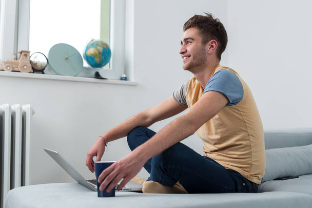 Handsome young smiling businessman working from home with a laptop - Foto, Imagem
