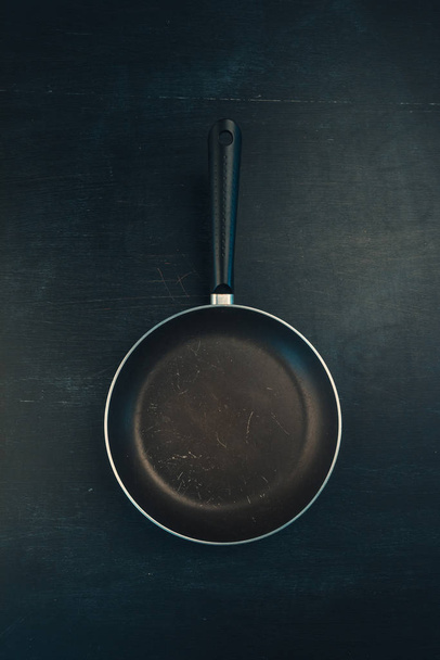Used old empty frying pan skillet top view on dark background - Fotó, kép