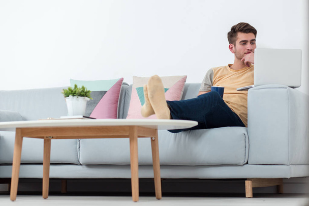 Man Working From Home Using Laptop on sofa in living room - Photo, Image