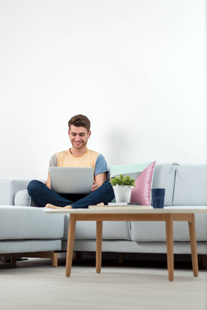 Man Working From Home Using Laptop on sofa in living room - Foto, Imagem