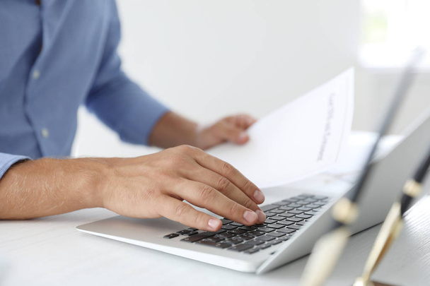 Mannelijke notaris werken met laptop aan tafel in kantoor, close-up - Foto, afbeelding