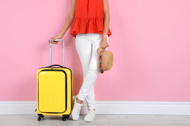 Woman with suitcase near color wall. Space for text - Foto, imagen