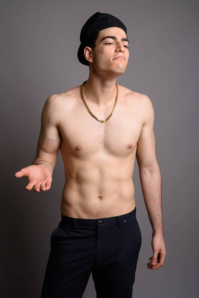 Fiatal jóképű férfi félmeztelen ellen szürke háttér - Fotó, kép