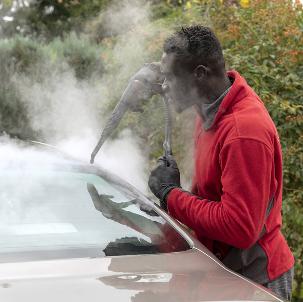 Ο άνθρωπος ατμού καθαρισμού ένα πολυτελές αυτοκίνητο σε ένα σπίτι που επισκέπτονται την υπηρεσία παρκαδόρου, Αγγλία Uk - Φωτογραφία, εικόνα