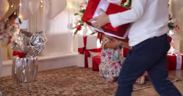 クリスマス ツリーの下にクリスマス プレゼントで子供. - 映像、動画