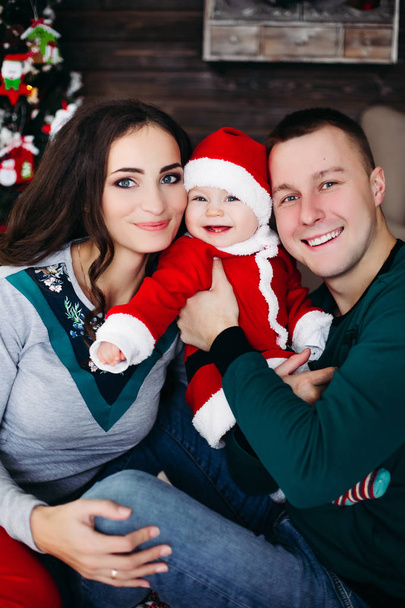 Happy family with adorable kid having fun at Christmas tree. - Foto, imagen