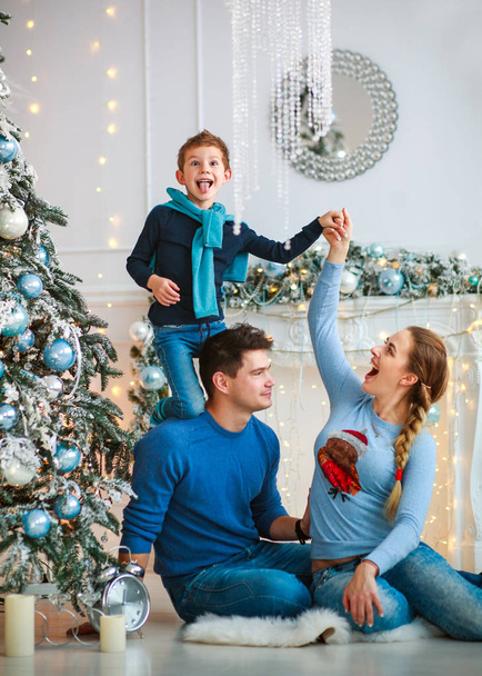 Happy friendly family decorating a Christmas tree have fun, father with his son on his shoulders - Fotografie, Obrázek